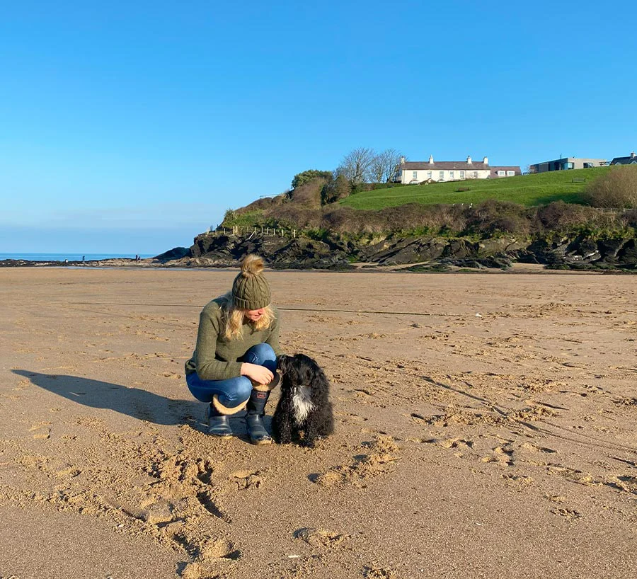 Melanie walking along a sandy beach at sunset.