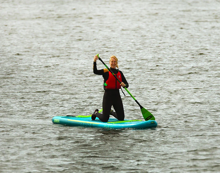 Melanie paddleboarding on calm waters in Pembrokeshire.