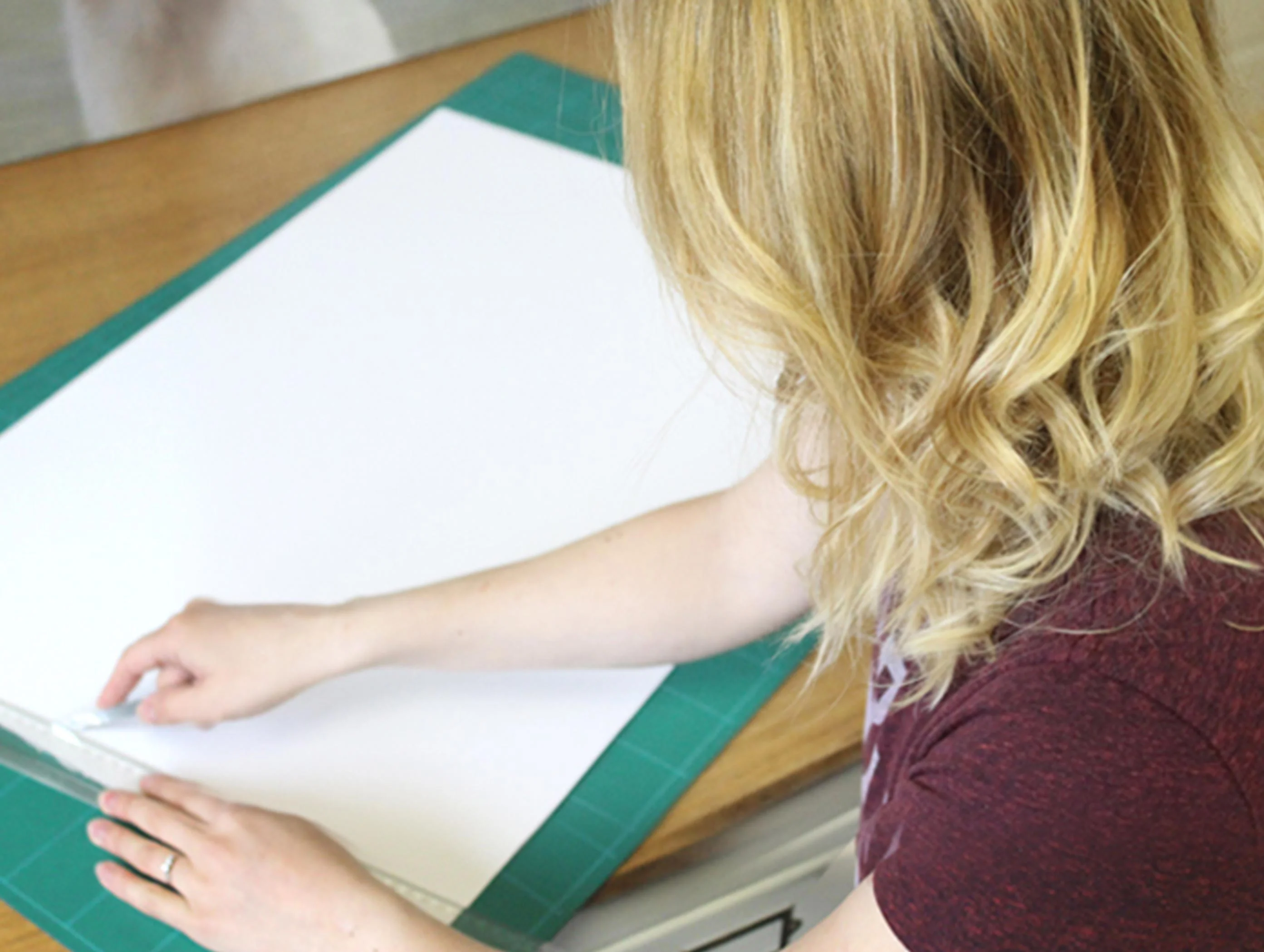 Melanie in her studio, carefully cutting Fabriano art paper.