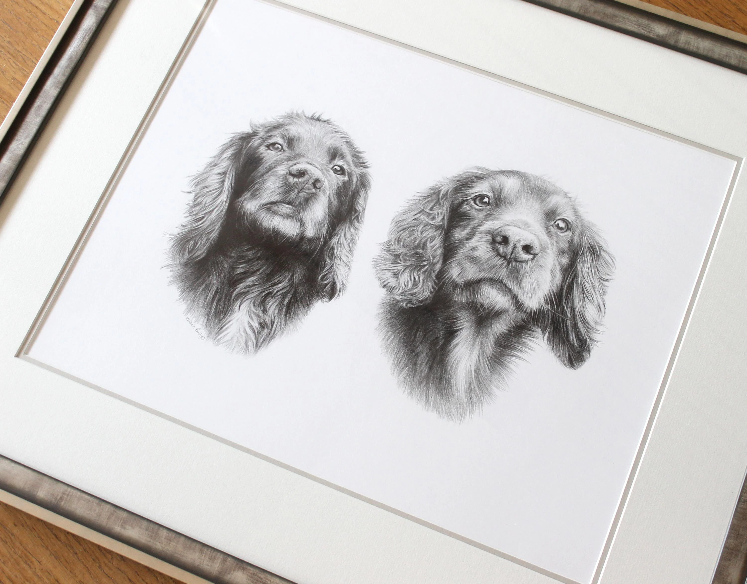 The framed pencil portrait of Jenny and Fern displayed in a home setting.
